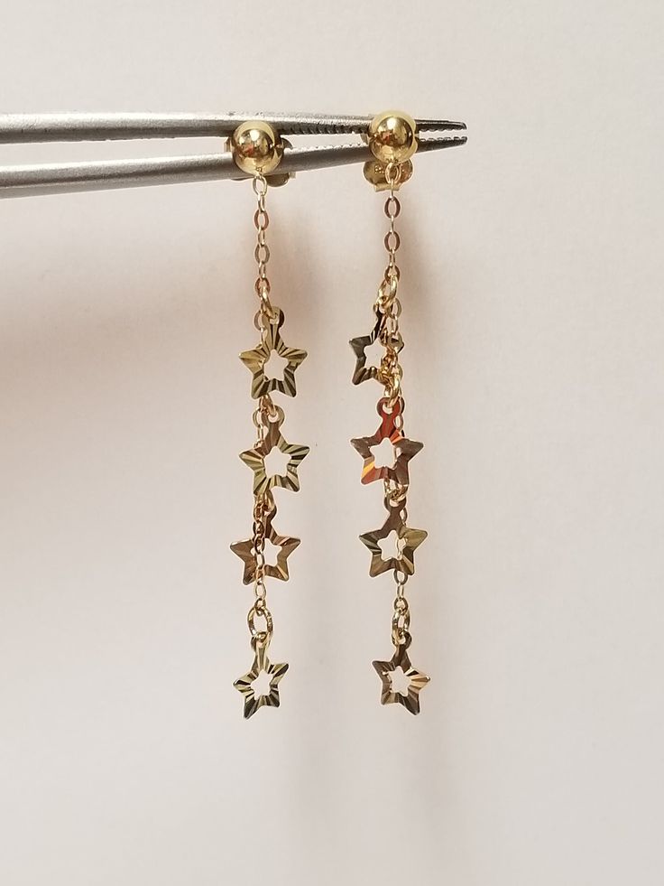 "Thanks for shopping our vintage estate store. We tend to sell well below wholesale and truly hope you enjoy all of our items. Many of the items are one of a kind, so please enjoy scrolling through the pictures and hopefully something will catch your eye. Brown spots are from camera or reflections. Nice estate 14k yellow gold ball star dangle earrings. Ball: 4mm Length: 1.5\" Width: 1/4\" Weight: 1.26 grams Earrings are marked 14k and backs are included." Vintage Gold Star Jewelry, Gold Star Charm Earrings In 14k Gold, Gold Earrings With Star Charm In 14k Gold, Anniversary Yellow Gold Star Charm Earrings, Anniversary Yellow Gold Earrings With Star Charm, Brown Spots, Dangly Earrings, Jewelry Lookbook, Gold Stars