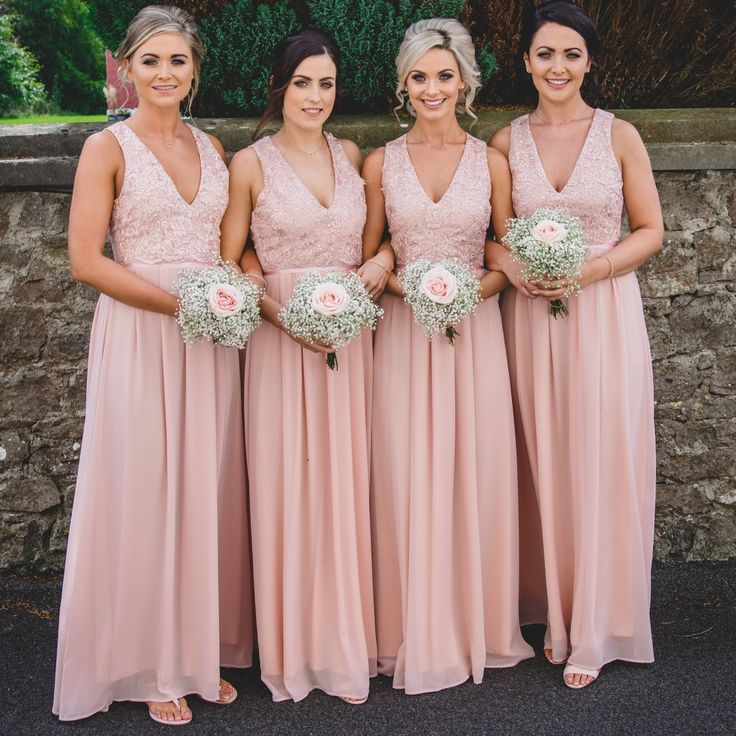 the bridesmaids are all wearing pink dresses and holding bouquets in their hands