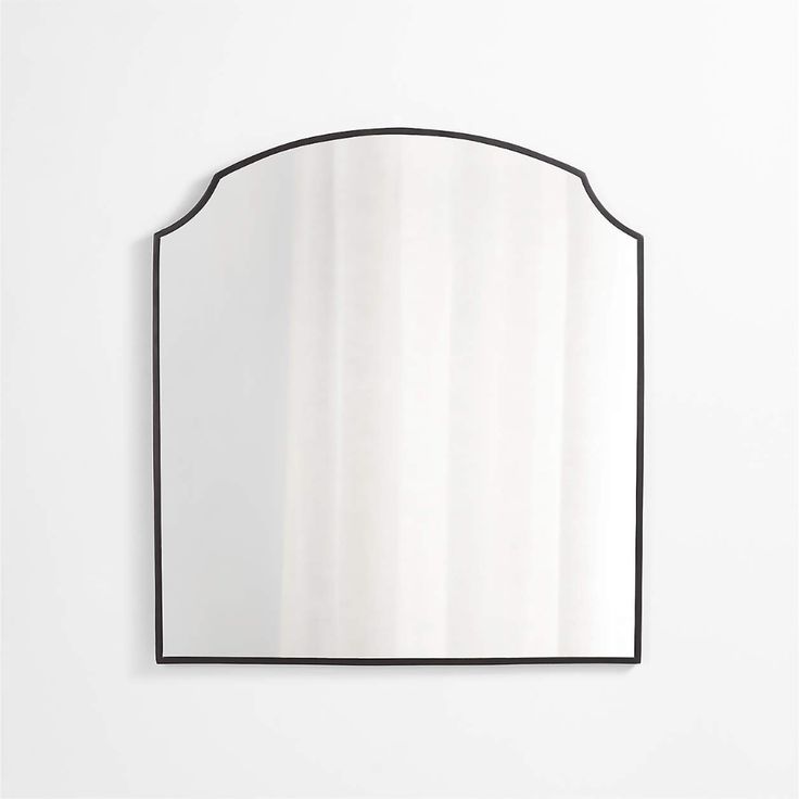 a mirror that is on the wall in front of a white wall with a black frame