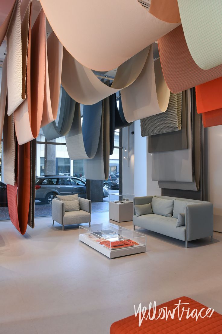 a living room filled with furniture and lots of hanging fabric on the ceiling next to a car