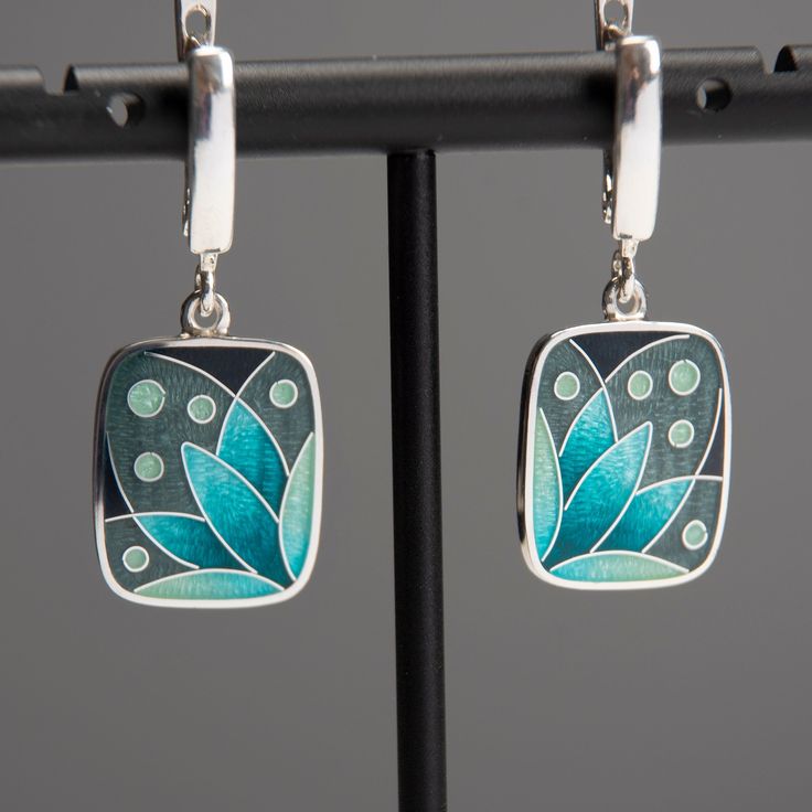 "Weight - 7 gr (approx) Length - 34 mm/1.33\" (including ear wire) Width - 15 mm/0.59\" Materials - Sterling Silver, Fine Silver, Cloisonne Enamel. Rectangle earrings with turquoise flower. Small and light earrings perfect fits for everyday wearing. The base underneath the enamel layer is engraved which gives my pieces even more loveliness and charm. Latch back ear wires has a safe lock and also made from Sterling Silver. Earrings covered with hot transparent enamel. Enamelling is an art of deco Pierced Dangle Earrings In Enamel, Elegant Turquoise Enamel Earrings, Green Hand Painted Sterling Silver Earrings, Nickel Free Enamel Dangle Earrings, Pierced Enamel Drop Earrings, Enamel Jewelry For Pierced Ears As A Gift, Green Hand Painted Drop Earrings, Enamel Dangle Jewelry With Matching Earrings, Silver Earrings With Black Enamel As A Gift