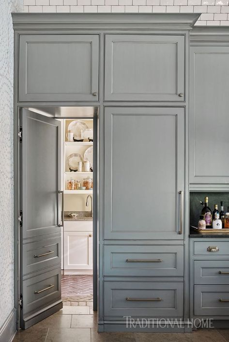 a kitchen with gray cabinets and white walls