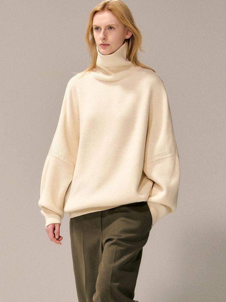 This luxurious oversized turtleneck sweater features a 15% wool blend composition and sophisticated drop-shoulder design that extends below the hip, offering versatile styling options from casual to dressy. The relaxed silhouette and premium fabric blend of wool, nylon, and acrylic create the perfect balance of comfort and elegance for year-round wear. Available in beige, brown, and black, this versatile piece can be worn alone during transitional seasons or layered under outerwear for added war Classic Oversized Turtleneck Sweater, Oversized Cozy Cashmere Turtleneck, Cozy Oversized Cashmere Turtleneck, Chic Oversized Turtleneck Sweater, Wool Turtleneck For Workwear, Wool Turtleneck For Work, Oversized Ribbed Collar Turtleneck For Fall, Oversized Fall Turtleneck With Ribbed Collar, Oversized Turtleneck With Ribbed Collar For Fall