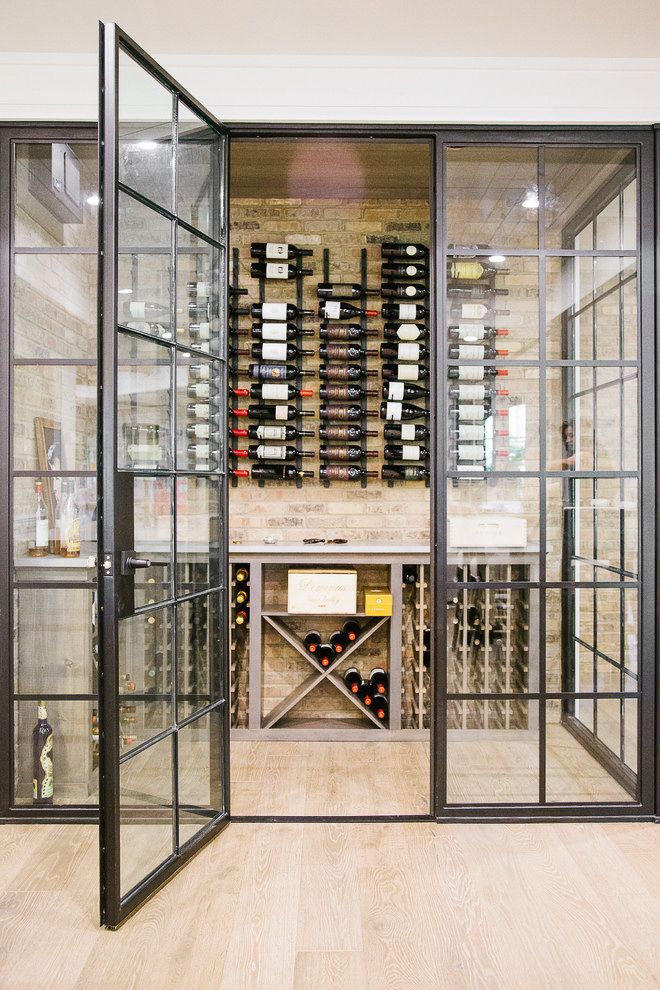 a wine cellar with glass doors and shelves full of bottles