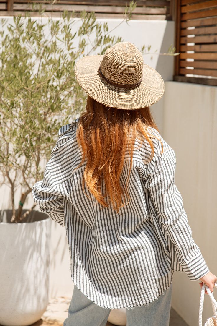 Stay cool and stylish this summer with our Zuma Button Down, featuring pretty iridescent buttons and a raw hem. This super lightweight top offers an effortless, relaxed, and roomy fit, making it perfect for warm weather. Best of all? Its 100% cotton! Wear it buttoned up for a polished look or unbuttoned over a swimsuit or tank for a breezy, casual vibe. This versatile piece is a must have summer staple! Malibu Collection FIT Relaxed Roomy Fit Iridescent Buttons High-Low Raw Hem Clancy is 5'9 Wea Casual Shirt For Beach In Fall, Casual Beach Shirt For Fall, Casual Shirt For Beach And Fall Season, Trendy Beach Shirt For Fall, Spring Beach Blouse With Button Closure, Chic Striped Shirt For Beach, Chic Vacation Tops With Button Closure, Relaxed Fit Beach Top With Shirttail Hem, Chic Tops With Button Closure For Vacation