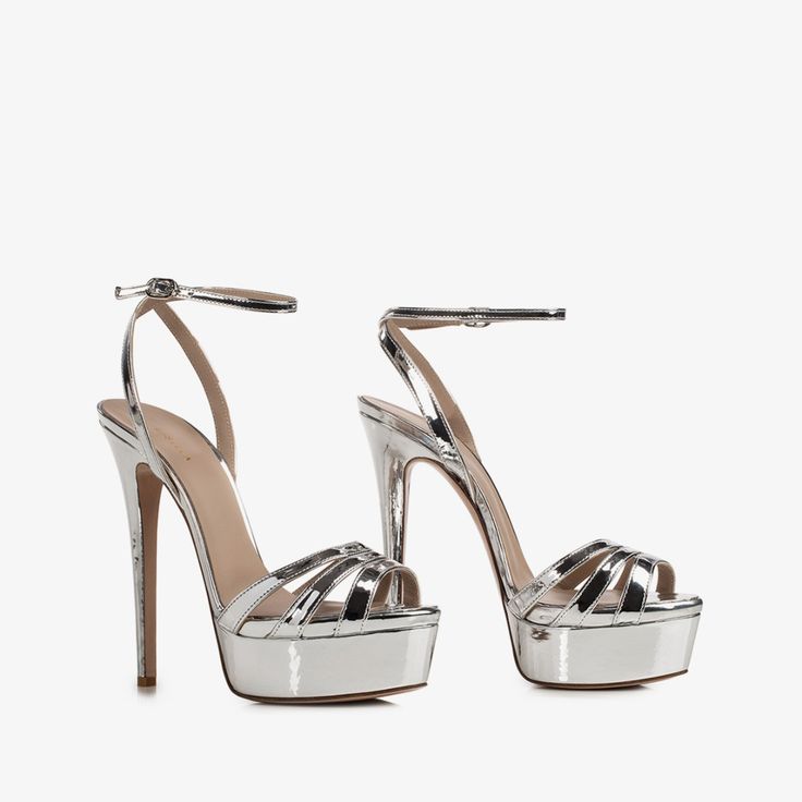 Luxury Silver Sandals With Heel Strap, Luxury Silver Platform Heels, Luxury Silver Elegant Wedge Sandals, Luxury Silver Metallic Leather Sandals, Luxury Silver Patent Leather Heels, Luxury Silver Ankle Strap Heels, Luxury Metallic Silver Open Toe Heels, Luxury Trendy Platform Heels, Luxury Metallic Silver Leather Heels