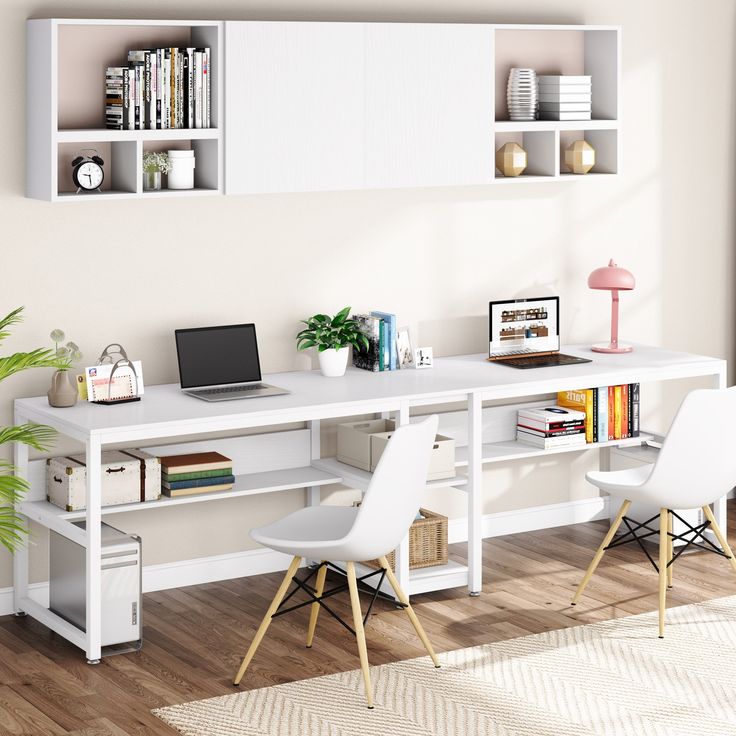 a white desk with two chairs and a laptop computer on it in front of a bookshelf