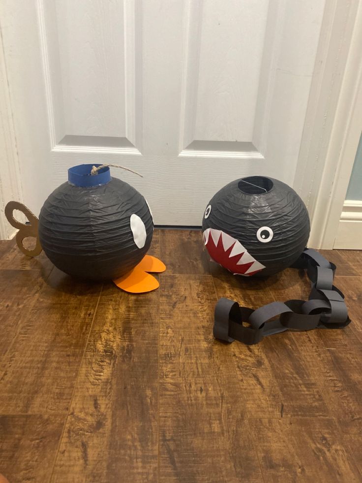 two halloween decorations are sitting on the floor next to each other, one with a shark face and another with a fish mouth