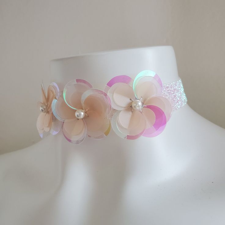 This cute floral choker necklace is the perfect accessory to finish your sparkly outfit! It adds the final touch to rave and music festival outfits, unicorn looks, sparkly fairy outfits, and pairs perfectly with our sequin kimonos. This choker is made of lightweight white iridescent elastic. There are three sequin flowers, hand sewn onto the necklace right here in our Los Angeles studio. It is adjustable with a back hook and chain. DETAILSLength: 12" (adjusts up to 20")Width: 1" SHIPPINGShips fr Spring Festival Adjustable Necklace, Summer Party Choker Jewelry, Spring Party Choker Necklace, Summer Pink Choker As Gift, Adjustable Pink Choker For Party, Pink Adjustable Choker For Party, Adjustable Multicolor Choker For Spring, Pink Bohemian Choker For Party, Adjustable Whimsical Choker