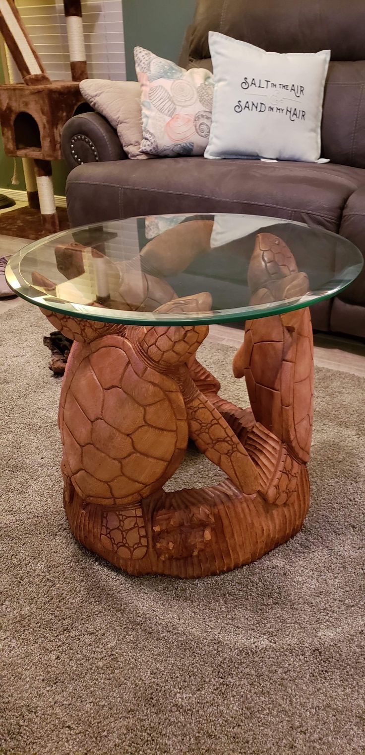 a coffee table with a glass top sitting on the floor in front of a couch