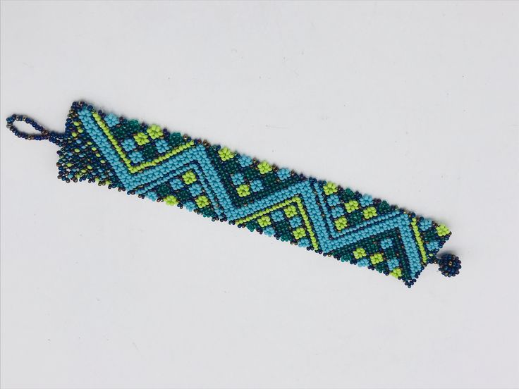 Vintage African Maasai Arrow Design Beaded Bracelet Turquoise and Green Blue Beads 8"  The Maasai bead work embodies a tradition that dates back more than a thousand years. The materials, colors, and patterns are rich with symbolism--often communicating romantic intentions. Handcrafted in Kenya this bracelet is in wonderful condition. Blue Artisan Adjustable Beaded Bracelet, Adjustable Blue Artisan Beaded Bracelets, Adjustable Artisan Blue Beaded Bracelets, Adjustable Blue-green Beaded Jewelry, Artisan Green Beaded Bracelets For Beach, Traditional Green Beaded Bracelets With Spacer Beads, Artisan Blue Beaded Bracelets For Beach, Artisan Green Beaded Bracelets With Round Beads, Artisan Green Beaded Bracelets