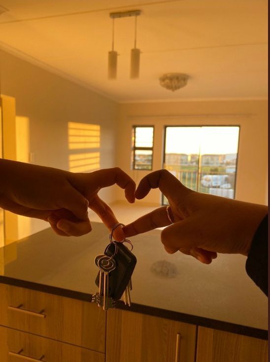 two people making a heart shape with their hands and holding keys in front of them