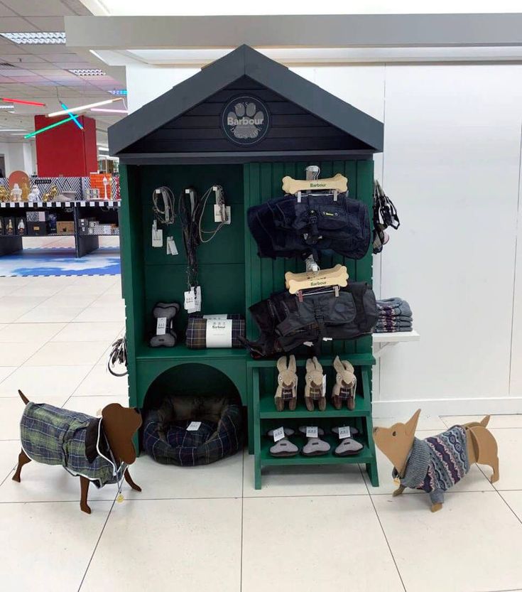 two small dogs are standing in front of a dog kennel with clothes on it