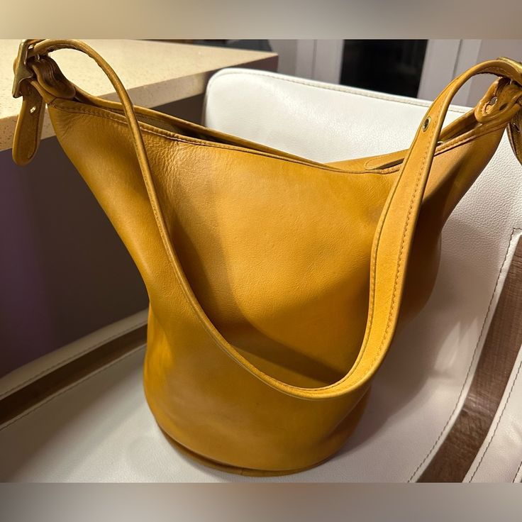 Amazing Vintage Coach Yellow Duffle Sac. Creed 9085. Made In The United States. Please Note The Imperfection On One Side. It Is A Big Spot But Adds To The Character. Missing Hang Tag Classic Gold Bucket Bag For Formal Events, Classic Bucket Bag, Classic Gold Bucket Bag For Shopping, Elegant Bucket Shape Bag With Leather Lining, Elegant Leather-lined Bucket Shoulder Bag, Classic Gold Bucket Bag For Travel, Elegant Yellow Bucket Bag With Detachable Strap, Elegant Bucket Shape Shoulder Bag With Leather Lining, Classic Bucket Shape Shoulder Bag