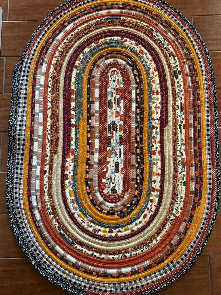 a multicolored round rug is on the floor in front of a wooden floor