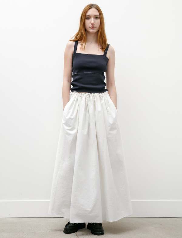 This voluminous skirt features slits at the narrow of the waist and cascades outwards with gathered pleating to finish below the knee. it features an elasticized waist with a toggle cinch and large pockets at the sides of the garment. its crisp cotton has a faded off white finish and a beautiful stone washed hand.    - made in the netherlands  - 100% cotton  - dry clean only  - hanna is 5’9”; bust 31.5” waist 25”; hips 35: wears a size small Elegant Bottoms With Gathered Waist For Spring, Elegant Spring Bottoms With Gathered Waist, Fitted Flared Skirt With Gathered Waist, Chic Spring Draped And Gathered Skirt, Spring Maxi Skirt With Gathered Waist, Flowy Tiered Skirt With Gathered Waist, Relaxed Ruched Skirt For Daywear, Chic Fitted Maxi Skirt With Gathered Waist, Chic Bottoms With Gathered Waist And Flowy Skirt