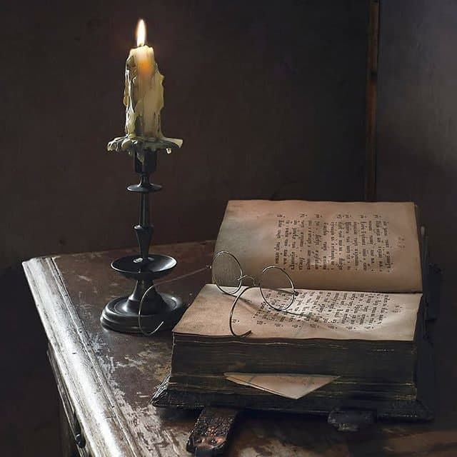 an old book and candle on a table