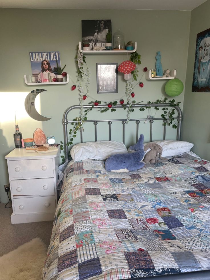 a bed with a quilt on top of it and some pictures above the headboard