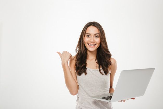 a woman is holding a laptop and smiling