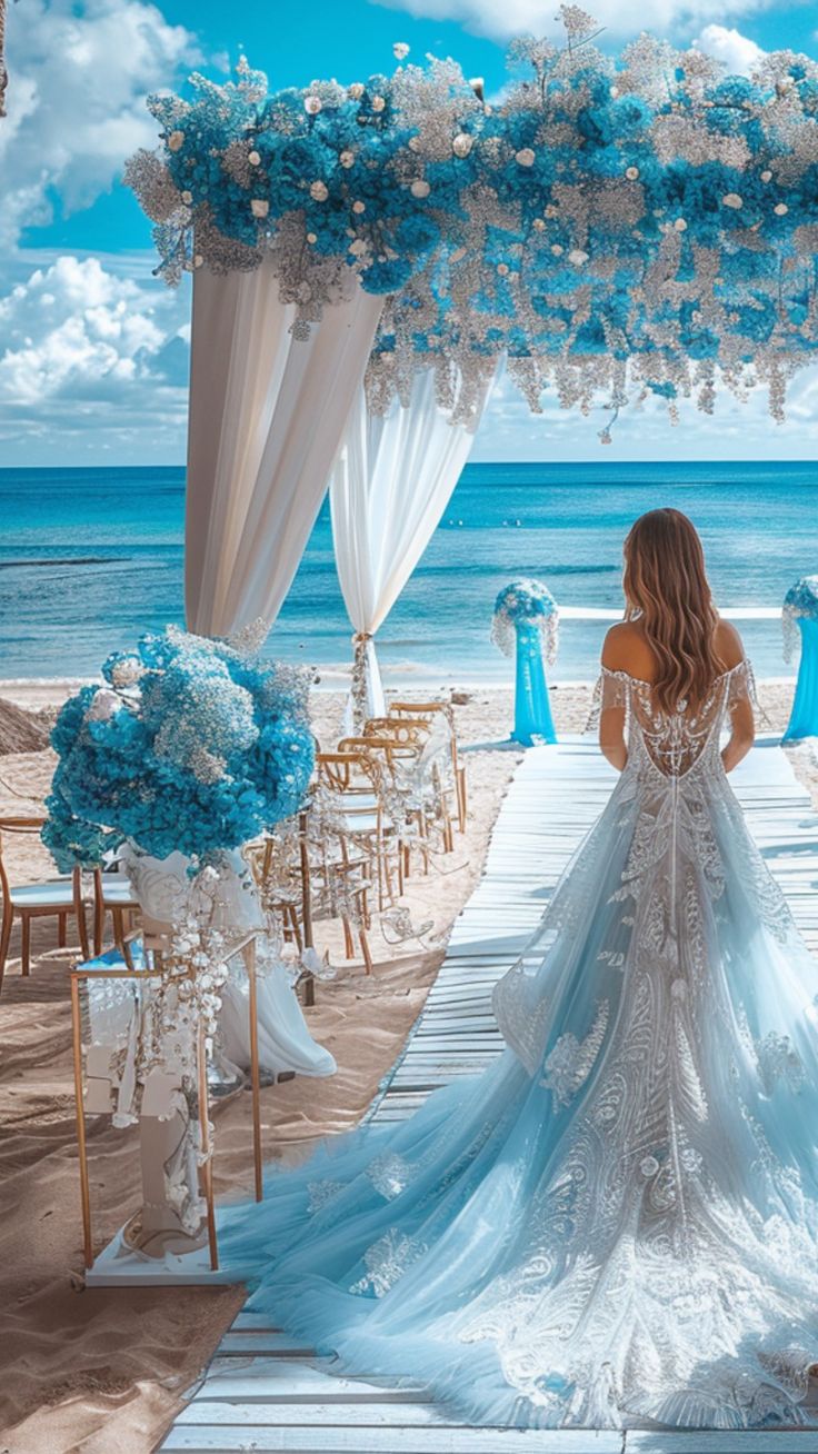 A bride stands at a beautifully decorated beach wedding entrance, surrounded by stunning seaside decor, ready for her special day. Beach Venues For Weddings, Wedding Decorations Beach Theme, Blue Beach Wedding Decorations, Wedding Venues By The Sea, Unique Wedding Location Ideas, Wedding Arches Beach, Beach Color Wedding, Sunflower Beach Wedding Ideas, Cute Beach Wedding Ideas