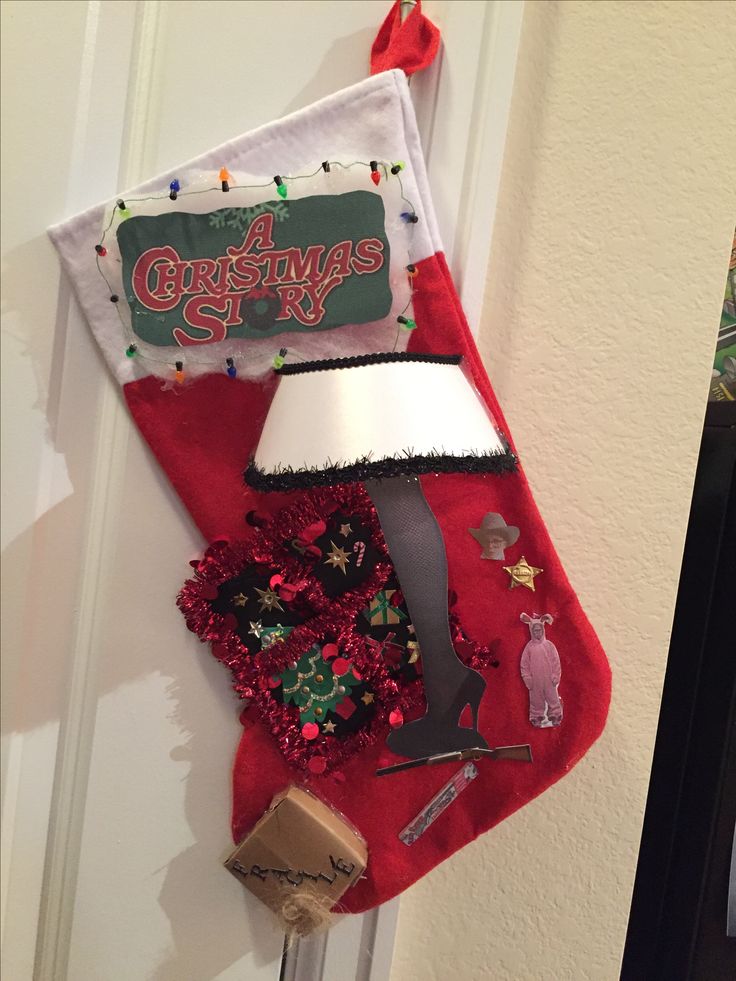 a christmas stocking hanging on the door with decorations around it and a lamp inside