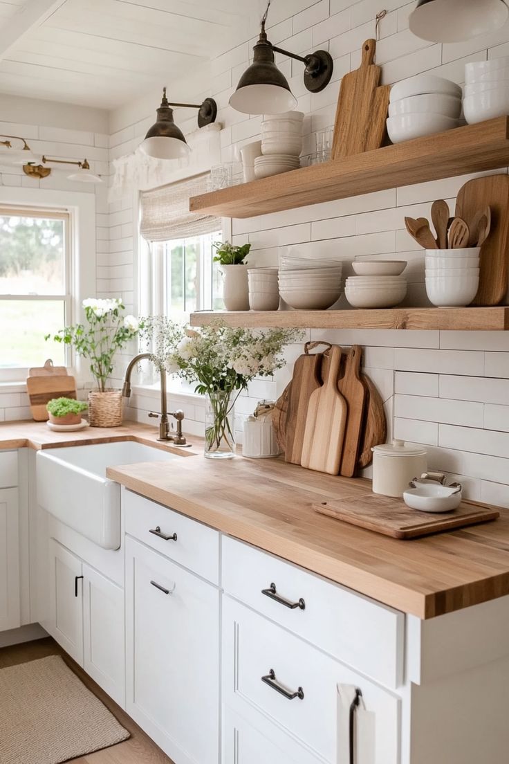 a kitchen with white cabinets and wooden counter tops, open shelving above the sink