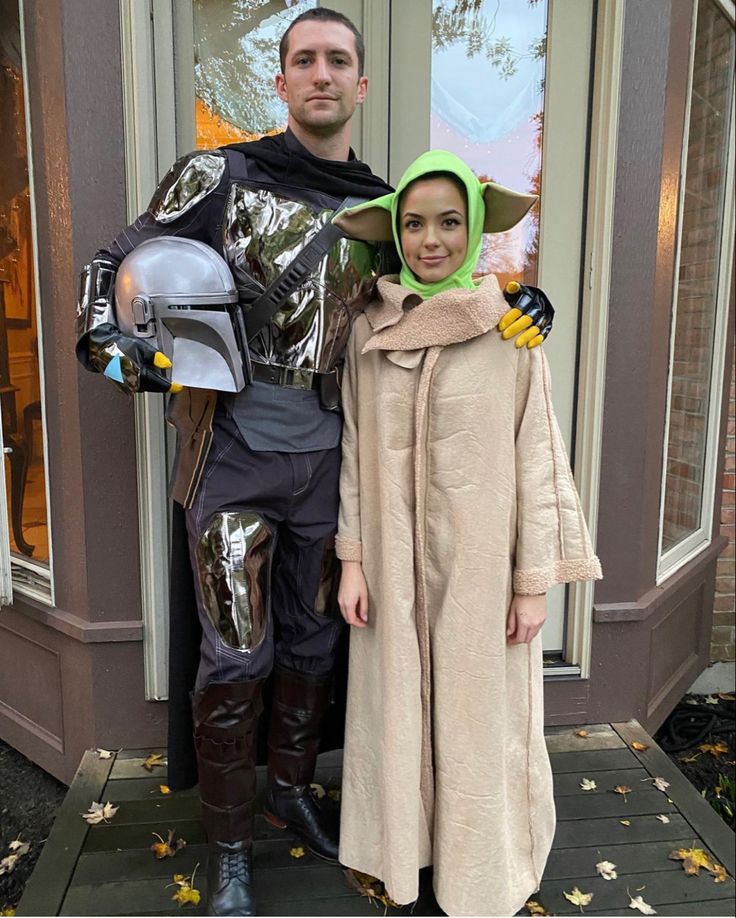 a man and woman dressed up as star wars characters standing in front of a building