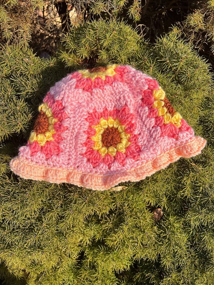 pink sunflower crochet granny square bucket hat, adult size small/ would fit best on smaller adult heads handmade in a smoke free and pet free house Pink Bohemian Flower Hat, Bohemian Pink Flower Hat, Bohemian Pink Crochet Hat For Spring, Pink Crochet Hat, Fun Style, Pink Bohemian Bucket Hat For Festival, Pink Handmade Flower Hat, Handmade Pink Flower Hat, Pink Flower-shaped Handmade Hats, Playful Pink Crochet Hat For Summer