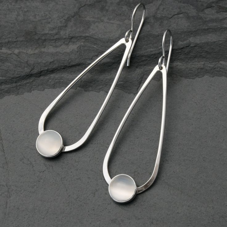 Teardrop Moonstone Earrings 8mm luminous moonstones are set in sterling silver on handmade sterling silver teardrops.   The teardrops swing from solid sterling silver ear wires. These earrings are 2 1/4 inches long including the ear wires.   5/8 inches at the widest part of the teardrop.   For more earrings: https://www.etsy.com/shop/KiraFerrer?section_id=7937255&ref=shopsection_leftnav_3 For more Teardrop gemstone earrings: https://www.etsy.com/shop/KiraFerrer?ref=hdr_shop_menu&search_query=tea Sterling Silver Drop Earrings, Earrings Round, White Moonstone, Earrings Inspiration, Moonstone Earrings, Silver Jewelry Handmade, Copper Earrings, Earrings Sterling Silver, Handmade Sterling Silver