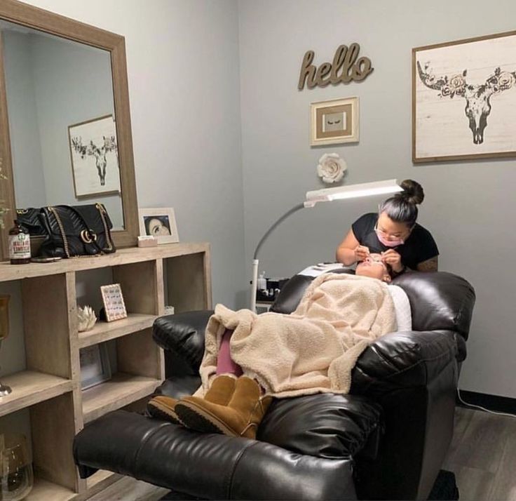 a woman is getting her hair done in a beauty salon with a mirror and shelves