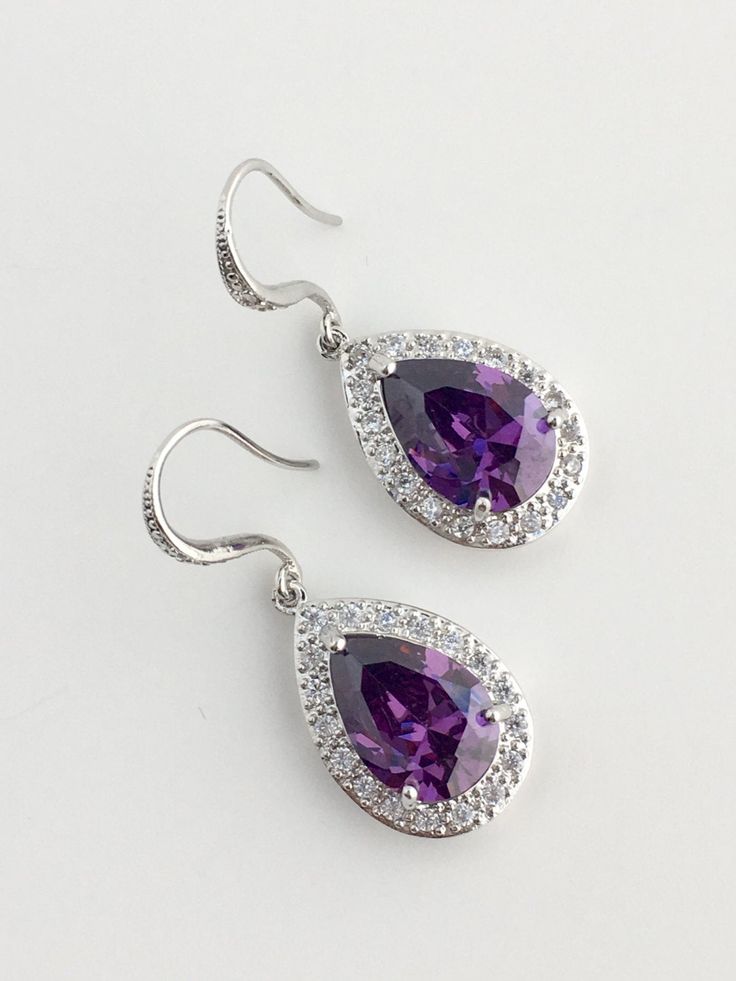 I've created these gorgeous purple amethyst cubic zirconia bridal tear drop dangle earrings in rhodium plated brass setting. Earrings feature a large teardrop with pear cut purple amethyst cubic zirconia center surrounded by tiny round zirconia crystals. Teardrop dangles from a cubic zirconia detailed ear wire. Total length of the earring is 3.8 cms. For matching necklace click: https://www.etsy.com/listing/479272957/amethyst-cubic-zirconia-teardrop-bridal?ref=shop_home_active_19 For matching br Purple Crystal Earrings For Wedding, Elegant Purple Jewelry With Ear Wire, Purple Earrings With Ear Wire For Anniversary, Purple Hook Earrings For Anniversary, Purple Bridal Earrings With Matching Set, Purple Anniversary Earrings With Ear Wire, Purple Pierced Earrings For Wedding, Purple Cubic Zirconia Earrings For Pierced Ears, Purple Sterling Silver Earrings For Party