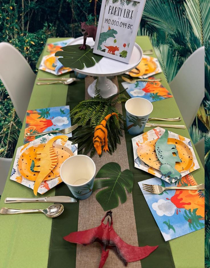 the table is set with plates, cups and utensils for children to eat