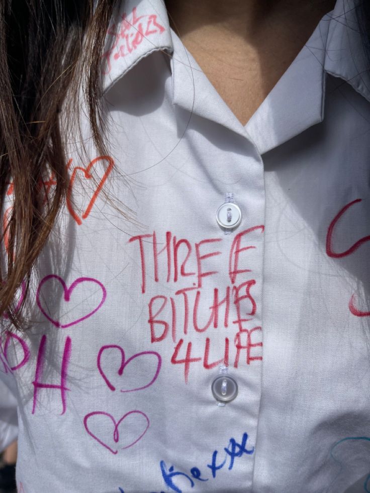 a close up of a person wearing a shirt with writing on it