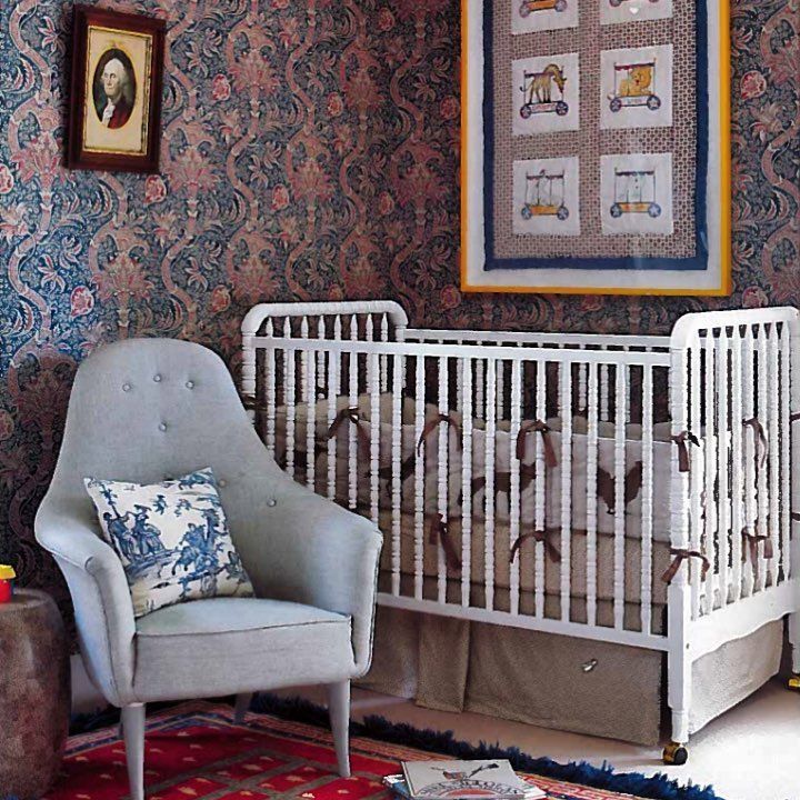 a baby's room with a crib, chair and rug in the corner