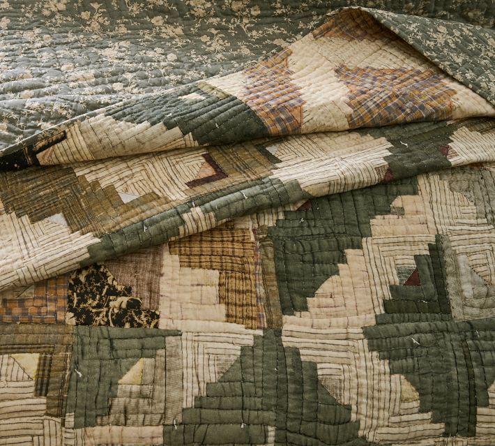 an old quilt is laying on top of a bed with it's comforter