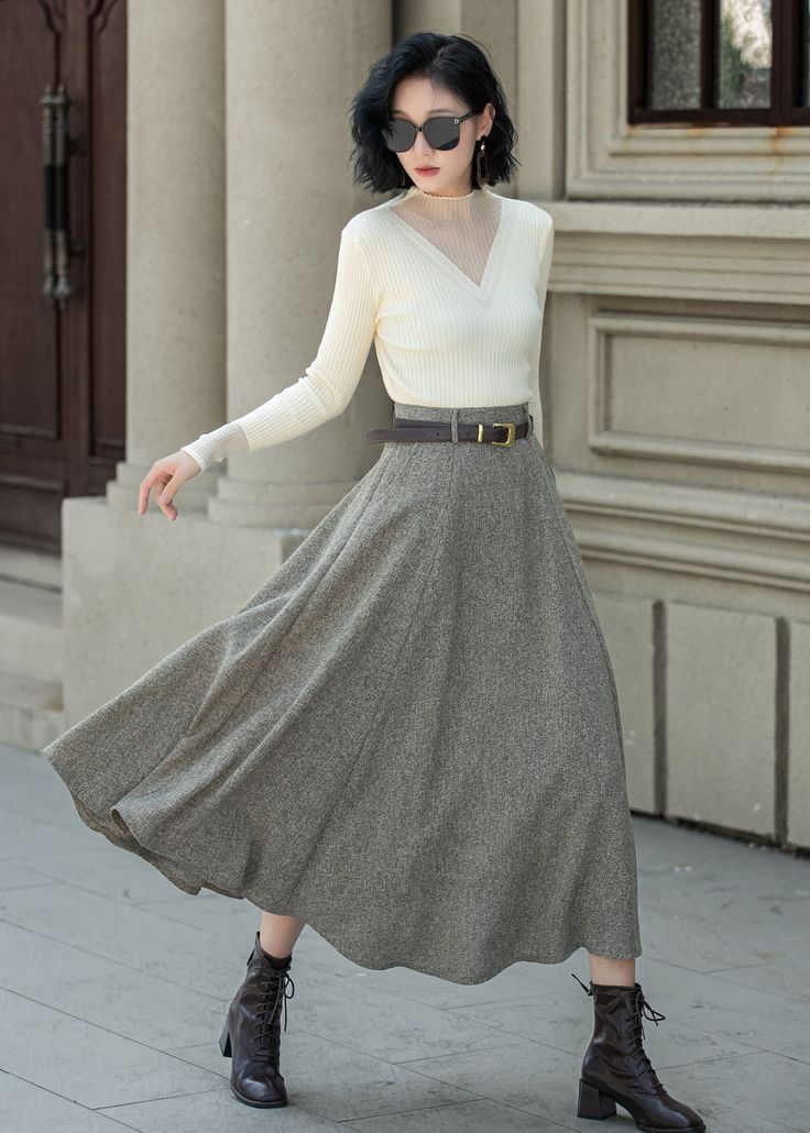 This is a very elegant skirt in wool with a high waist and belt loops, so you can wear it with a belt like the model, and wear it casually with boots and a coat in autumn and winter. DETAIL * 30% wool, 30% fiber, 40% polyester * Polyester lining * Two side Seam pockets * Right zipper closure * Midi calf length * A Line maxi skirt * Perfect for Winter, autumn * Dry clean MODEL SIZE Bust 85 cm(33.4")  Waist 67 cm(26.7")  Height 168cm (5' 6") She wears size XS CUSTOM MADE SERVICE If you * Change other color * Can't find your size in our size Chart * Change the Style * Change the length * Your Height is not Between 5'1" - 5"9" * Your weight is not Between 47 kg - 75kg I can do it for you, It will need some extra fee depending on on your need. Contact with me for more detail. SIZE GUIDE Size va White A-line Skirt For Fall, Elegant A-line Bottoms For Winter, Elegant Solid Pleated Skirt For Winter, Elegant Wool Full Skirt, White Flared Skirt For Winter, Winter Beige Flared Skirt, Beige Flared Skirt For Winter, White Flared Maxi Skirt For Fall, Elegant A-line Fall Skirt