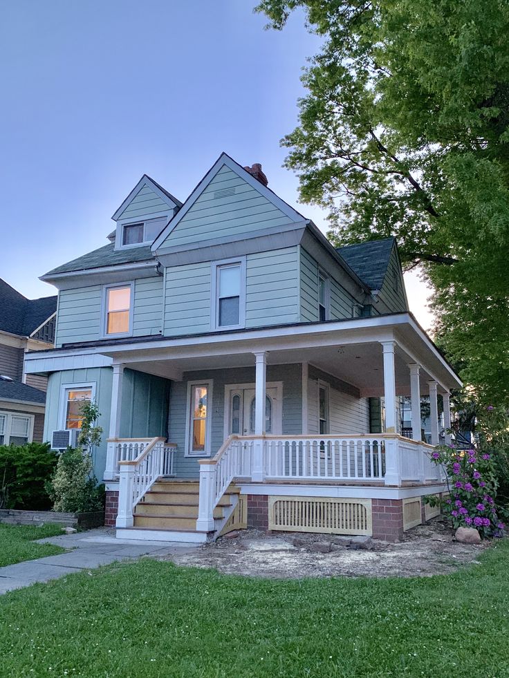 a house that is in the grass with stairs leading up to it's front door