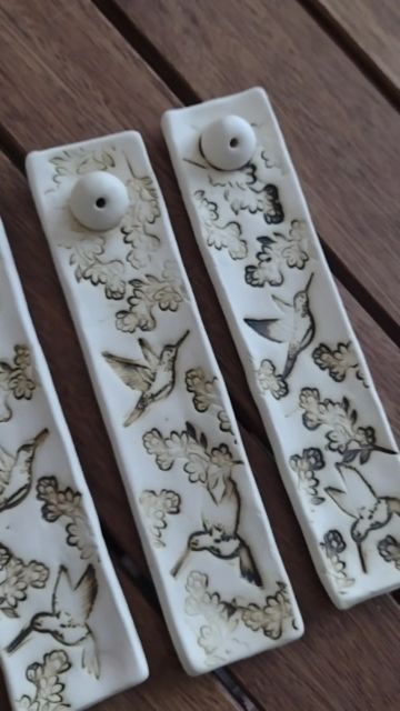 three white ceramic door handles with birds and flowers on them