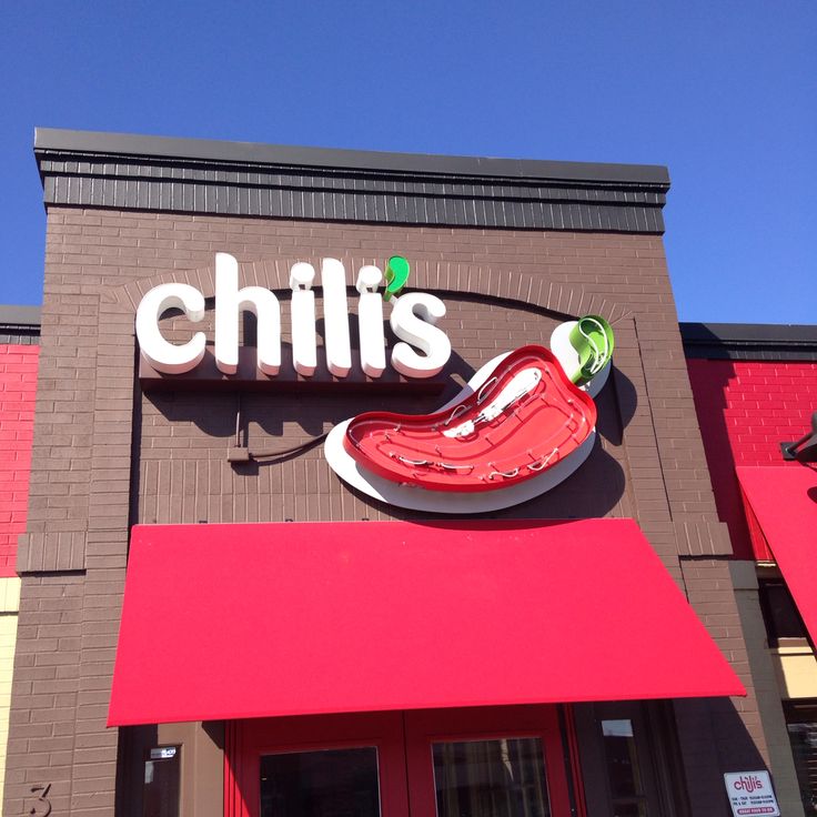 the sign on the building says chilli's with a giant red hot dog