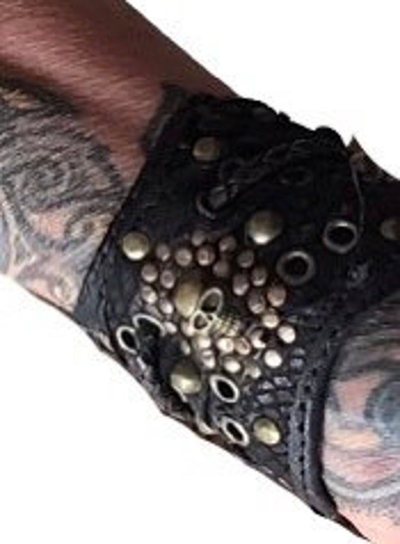 Stunning studded black leather cuff-bracelet Handmade with ❤️ passion and patience Definitely a little piece of wearable art. Skillful construction,attention is paid in every detail ! Decorated with bronze rivets & skull. Fits most sizes 3 small Snap-buttons to adjust. -------Dont forget to sent a msg if you like bird or human skull.----- I used up-cycled & recycled leather,to make this item. ------------------------ Skull Fits, Leather Burning, Goth Biker, Goth Shop, Black Leather Cuff Bracelet, Psy Trance, Steampunk Goth, Leather Bra, Black Gladiator Sandals