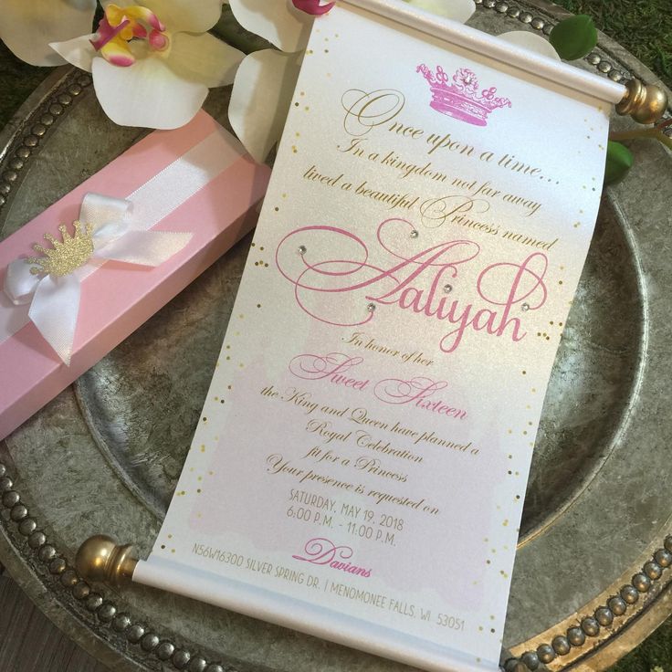 a pink and white wedding card on top of a silver platter with flowers in the background