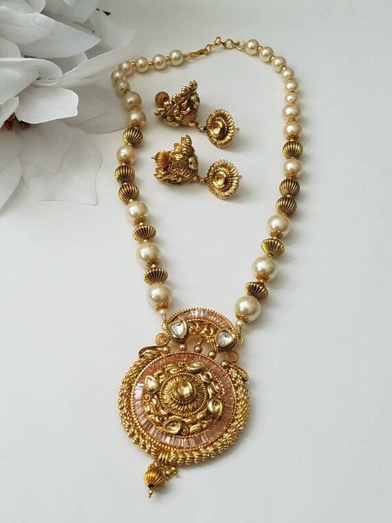 Check out this item in my Etsy shop https://www.etsy.com/listing/701925666/gold-necklace-indian-jewelry-indian Heavy Gold Pearl Necklace For Festivals, Gold Chandbali Pearl Necklace In Temple Jewelry Style, Gold Chandbali Pearl Necklace In Temple Style, Gold Chandbali Pearl Necklace With Intricate Design, Gold Pearl Necklace With Intricate Design For Diwali, Heavy Gold Pearl Necklace For Diwali, Diwali Gold Pearl Necklace With Intricate Design, Gold Pearl Necklace With Latkans Temple Style, Festival Gold Plated Chandbali Bridal Necklace