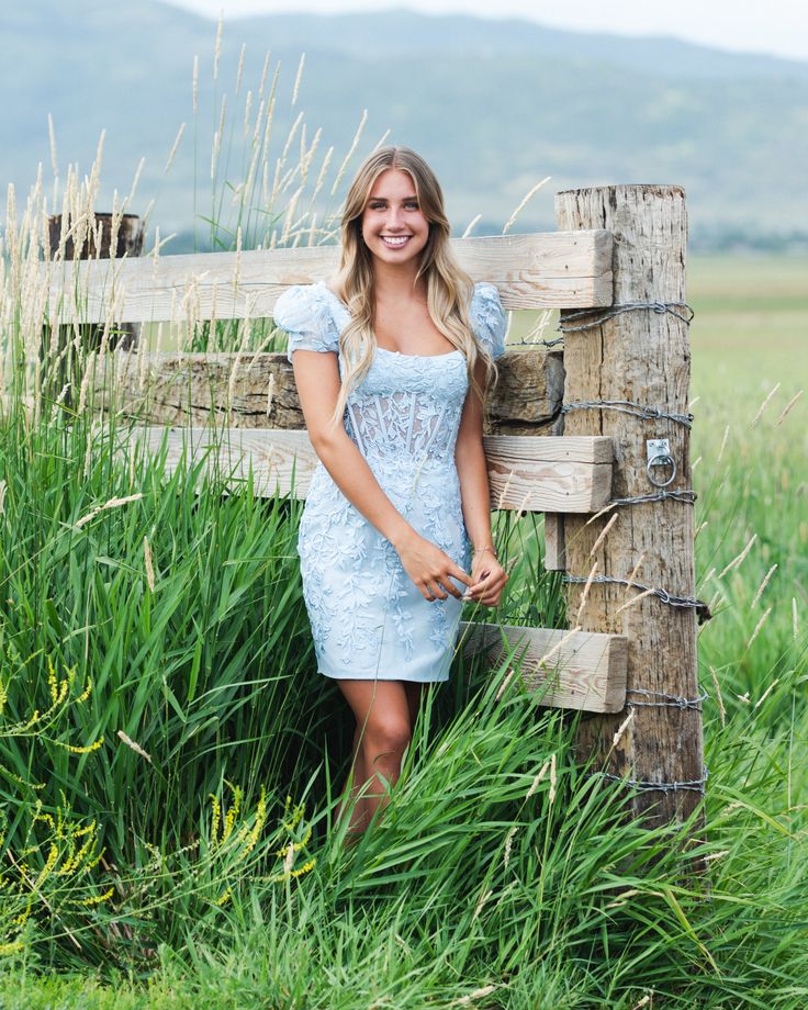 A model in a Sherri Hill cocktail dress features intricate leaf lace fabric with a scoop neckline. We are in love with the trending corset sheer bodice and the balloon sleeves give it a feminine, youthful detail. Elegant Homecoming Lace Dress With Fitted Bodice, Fitted Dress With Sheer Balloon Sleeves, Lace Dress With Fitted Bodice For Homecoming, Feminine Puff Sleeve Lace Dress For Party, Fitted Lace Dress With Puff Sleeves, Fitted Puff Sleeve Lace Dress, Elegant Puff Sleeve Corset Dress For Prom, Fitted Puff Sleeve Dress With Sheer Sleeves, Fitted Feminine Lace Dress With Puff Sleeves