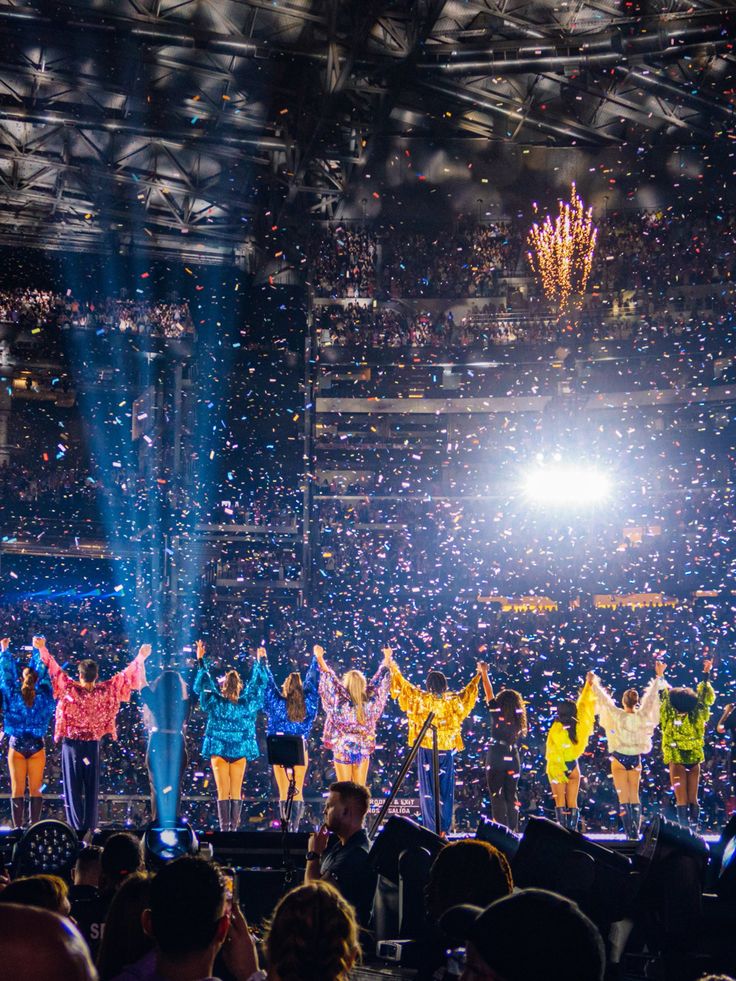 a group of people standing on top of a stage with confetti in the air