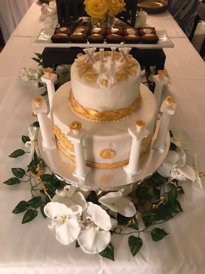 a wedding cake on a table with flowers and chocolates