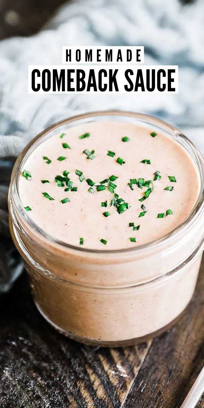 a small glass jar filled with sauce and topped with chopped parsley on a wooden table