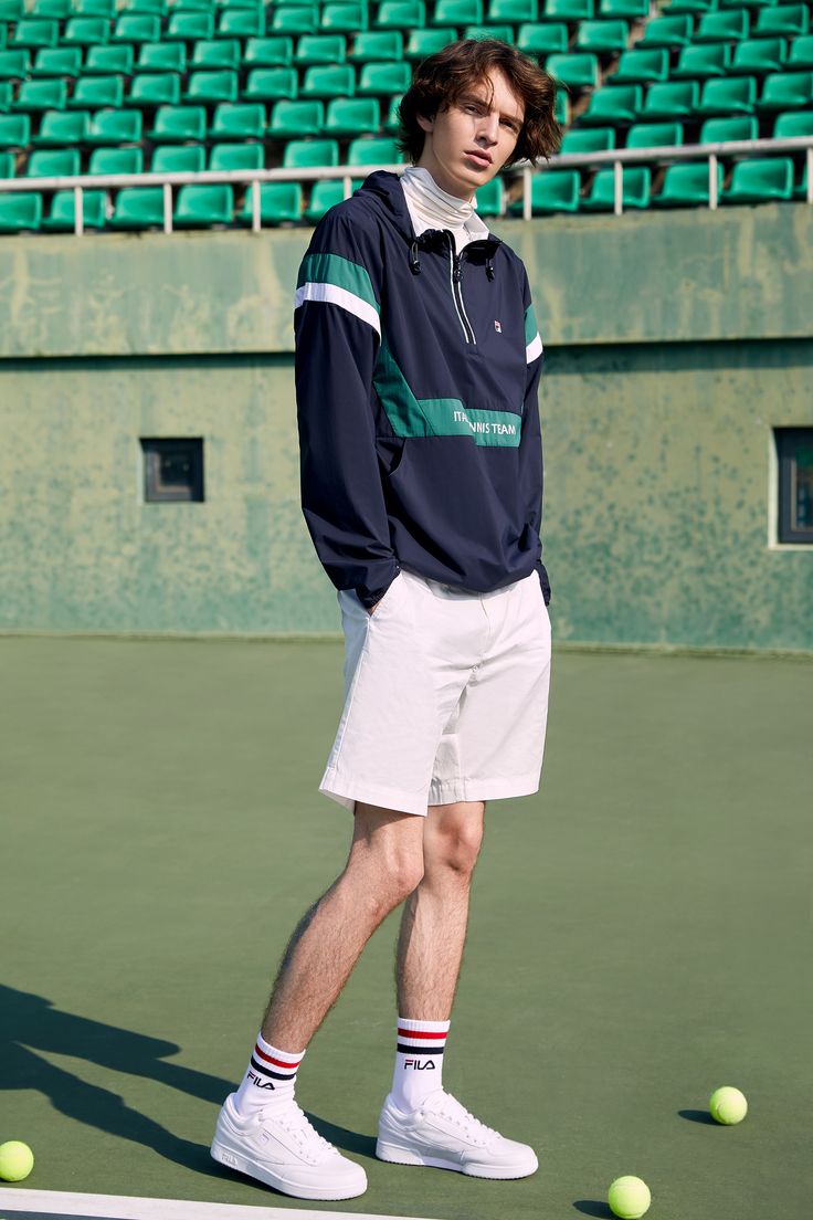 a man standing on top of a tennis court holding a racquet and ball