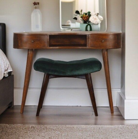 a small wooden desk with a mirror and stool in front of it on the floor