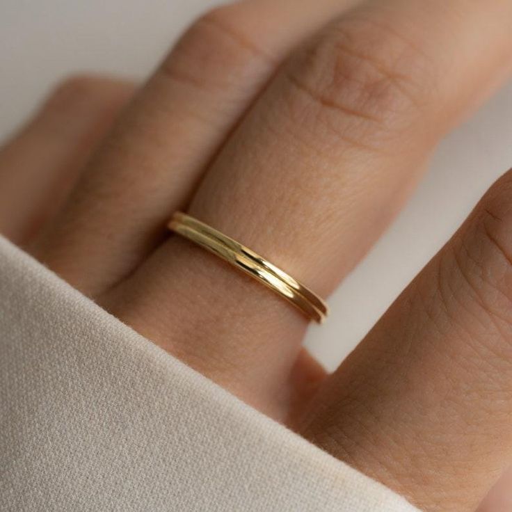 a woman's hand with a gold ring on it