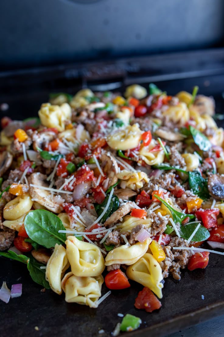 a pile of pasta with meat and vegetables